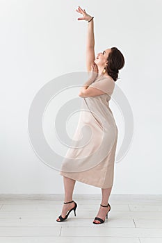 Latina dance, strip dance, contemporary and bachata lady concept - Woman dancing improvisation on a white background photo