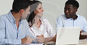 Latina female employee and teammates use laptop discuss online presentation