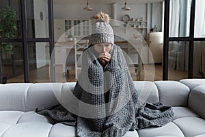 Latina female shiver at freezing flat in warm cap blanket