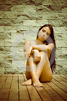 latina model sitting naked on wooden floor