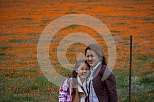 Latina Mother and Daughter in front of desert California Poppy field orange bokeh