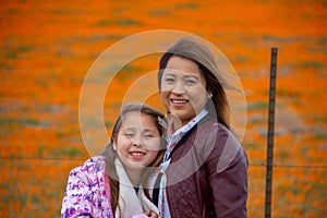 Latina Mother and Daughter in front of desert California Poppy field orange bokeh