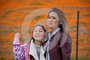 Latina Mother and Daughter in front of desert California Poppy field orange bokeh