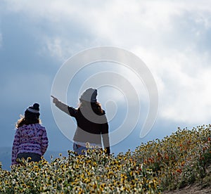 Latina Mother and Daughter in front of desert California Poppy field on path with orange and yellow flowers