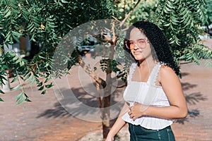 Latina teenager in the park. Portrait of a beautiful young teenage girl on a sunny day