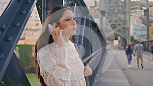 Latina woman looking smartphone screen waiting friend at river bridge closeup