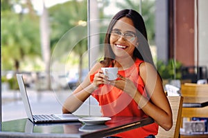 Latinamerican girl have a coffee break in a cafe photo