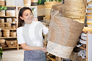 Latino american woman choosing wicker baskets in shop