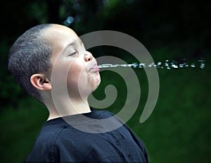 Latino boy spitting water photo