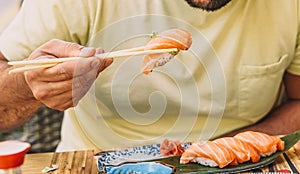 Latino boy in yellow t-shirt eating japanese food