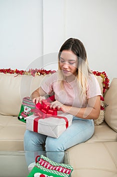 Latino Christmas woman opens a gift at home