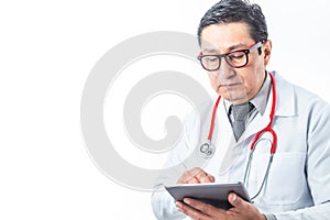 Latino doctor in white coat, stethoscope and tie checking his tablet on white background. Medical technology concept