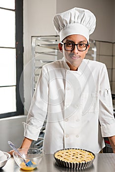 Latino man in a chef's uniform working in a bakery.