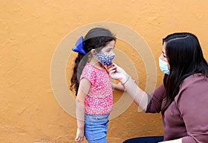 Latino family, woman and 5-year-old girl with covid-1 protection mask, ready for back to school