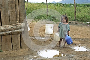 Latino girl goes to fetch water in mountain landscape