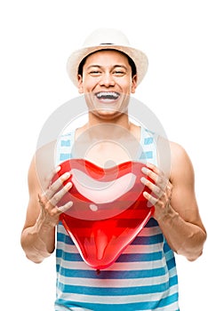 Latino man holding red heart balloon