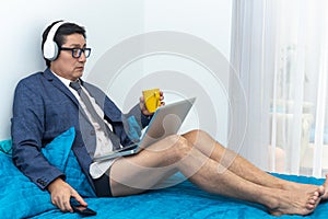 Latino man with tie and underwear works at home with his computer