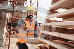 Latino Manual Worker With Forkift Pallet Stacker In Construction Site