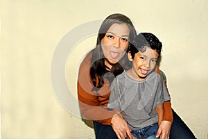Latino mother and son playing making faces having fun playing being happy