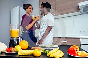 Latino woman and man working at juice bar and cutting fruits, making fresh smoothies from bananas,orange and melon. she