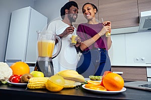 Latino woman and man working at juice bar and cutting fruits, making fresh smoothies from bananas,orange and melon. she