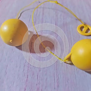 Lato-lato is a traditional toy consisting of a pair of plastic or rubber balls attached to a string to form a pendulum.