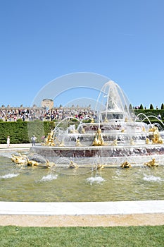 Latona fountain at Versailles Palace with crowd in background in portrait aspect