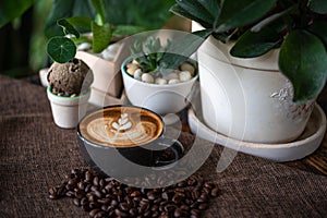 Latte art coffee in black cup with coffee beans