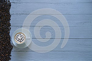Latte art coffee in a coffee cup left side  top view isolated on white wooden background