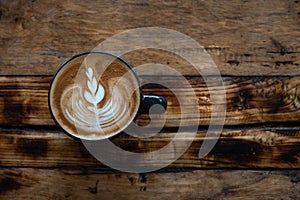 Latte art coffee cup on wooden table