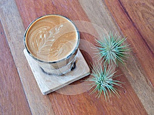 Latte art coffee on the wood saucer.