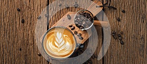 Latte art on hot latte coffee. Aroma coffee cup and coffee beans on wooden desk