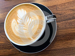 Latte art in mug on wooden table photo