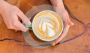 Latte art on wooden table. Cup of coffee with heart shape. good morning coffee. Cappuccino style. barista serve coffee