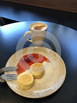 Latte with cinnamon and cheesecakes with strawberry jam