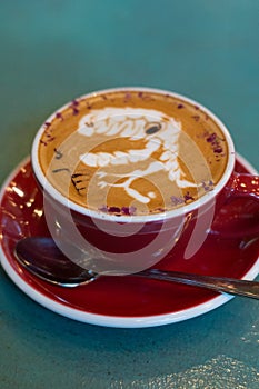 Latte coffee with latte art in a coffee cup with tea spoon