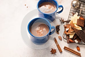 Latte coffee in two blue cups, sweets, chocolate, cinnamon sticks, almonds on a white background. Romantic breakfast, Valentine`s