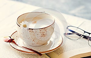 Coffee latte with flower and book. Morning concept. Romantic vintage photo with daisy