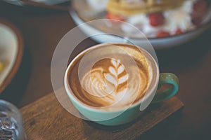 Latte hot coffee with foam milk art on a wooden table