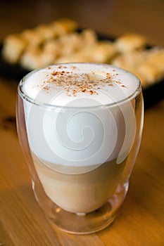 Latte macchiato in the glass with cookies