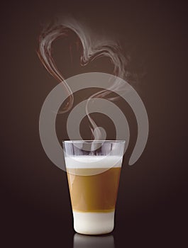 Latte macchiato with steam in heart shape photo