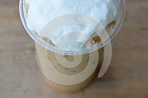 Latte and milk froth in plastic cup