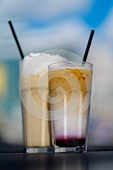 Latte with whipped cream and milky berry cocktail with blackberries and caramel