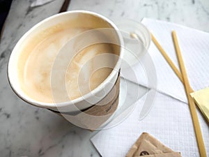 Latte in a White To Go Cup on a Marble Background
