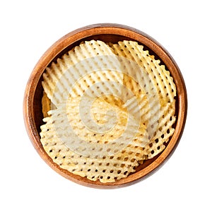 Lattice cut potato chips, salted crisps with grid pattern, in a wooden bowl