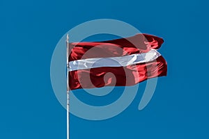 Latvian flag blowing in the breeze.