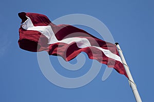 Latvian flag in the blue sky