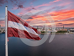 Latvian flag with the Dome Cathedral and an old town in the background photo