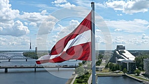 Latvian flag with the Dome Cathedral and an old town in the background in Riga, Latvia