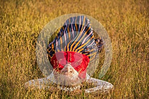 Latvian woman in traditional clothing in field.